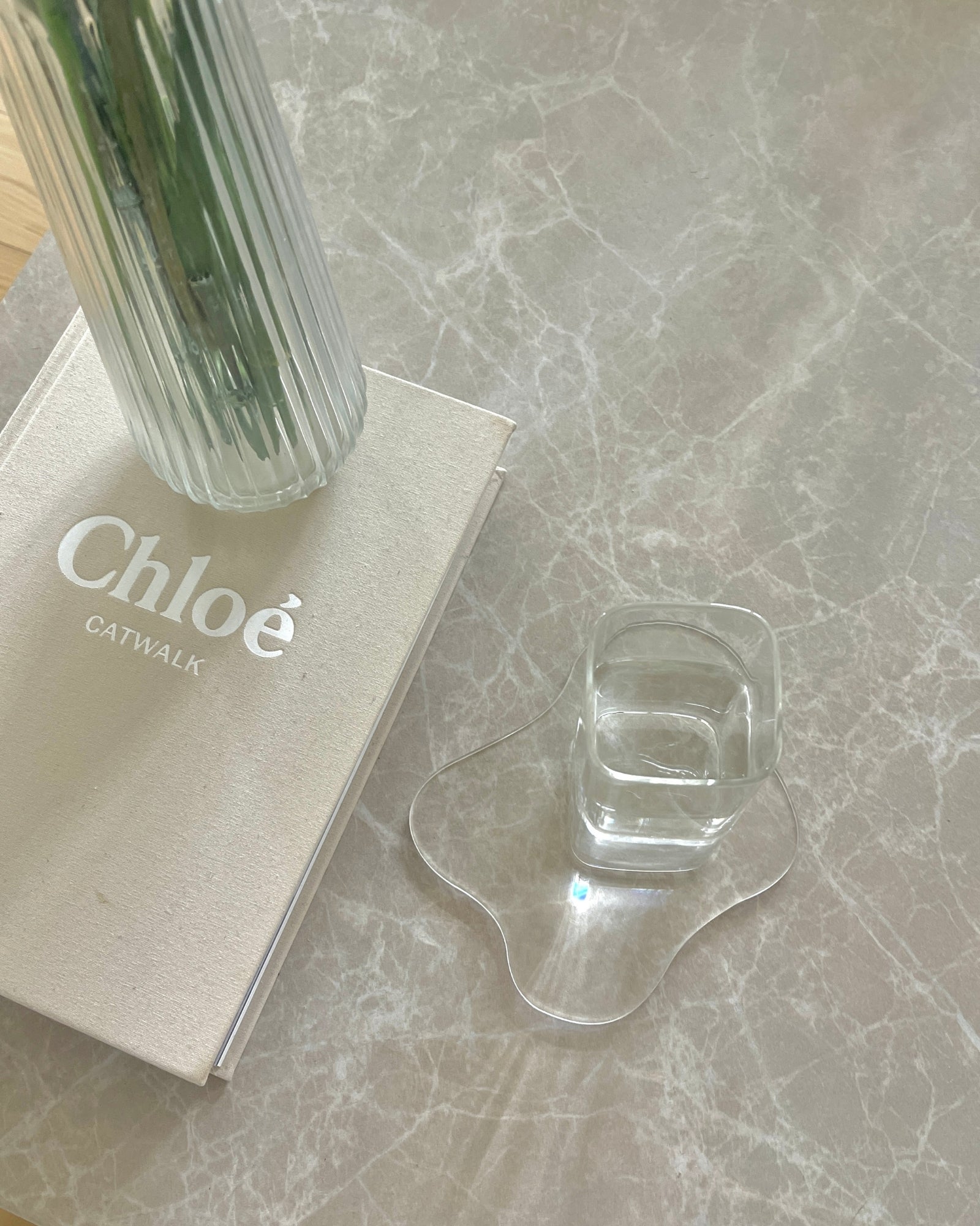 Olivia firkantet glas i minimalistisk glasdesign fyldt med vand på Isabella akryl drinkunderlag