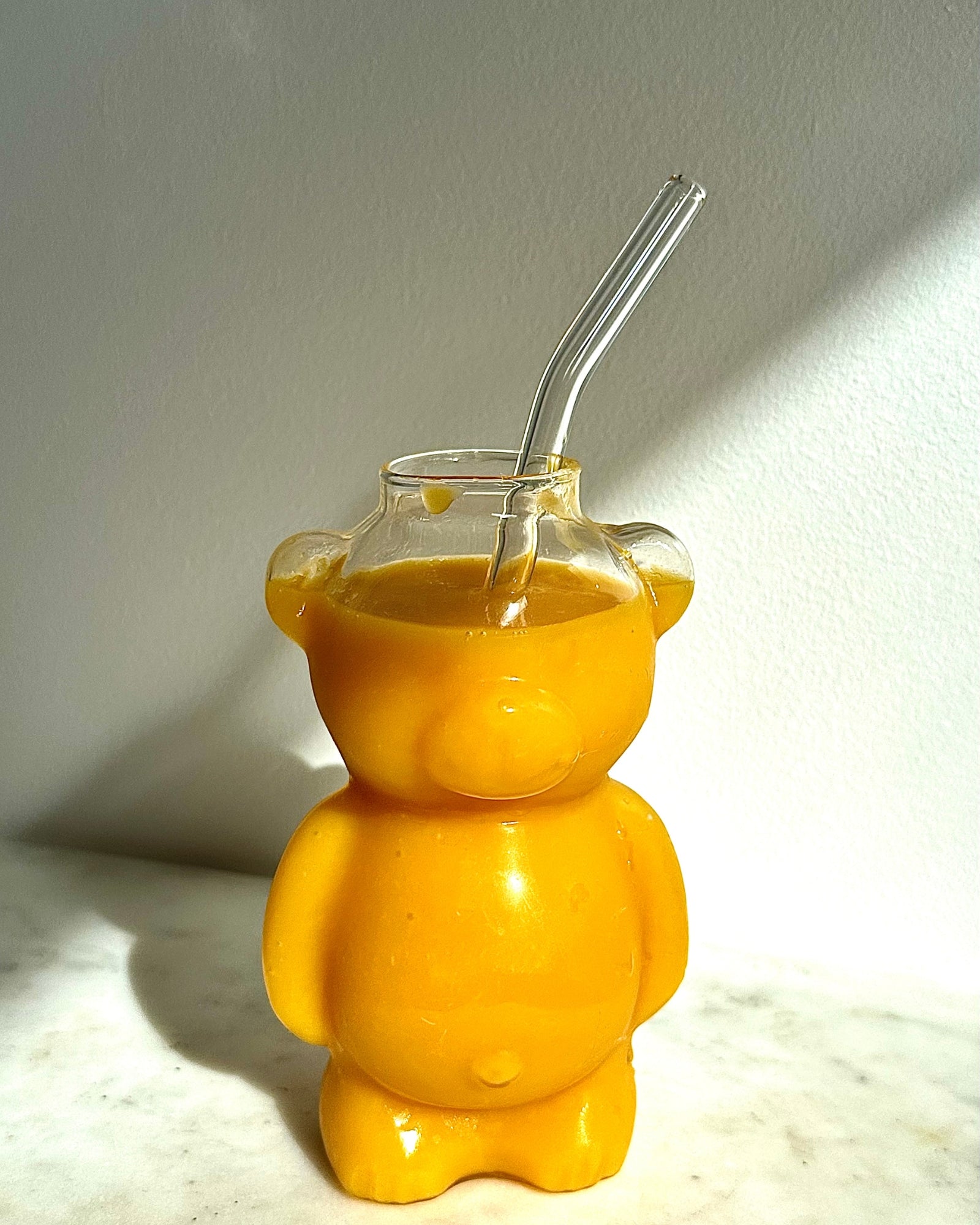 Appelsinjuice serveret i Poppy glasset, der er formet som en bamse