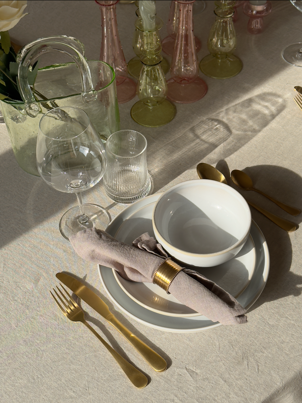 Borddækning med Knabstrup Keramik Tavola frokosttallerken, middagstallerken og skål i silkemat hvid samt Emily Curved drikkeglas i riflet design. Bordpynt består af Lily håndtaskevase i grøn og Lulu svampe fyrfadsstage i pink